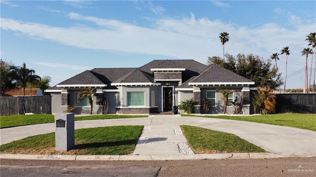 prairie-style home featuring driveway, a front yard, and fence