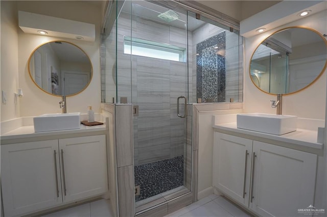 full bathroom featuring a shower stall, two vanities, and a sink