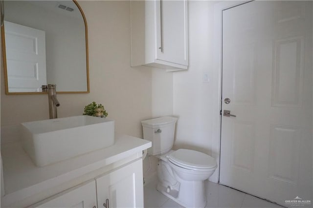 half bath featuring tile patterned floors, visible vents, toilet, and vanity