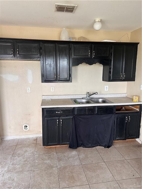 kitchen featuring light tile patterned floors and sink