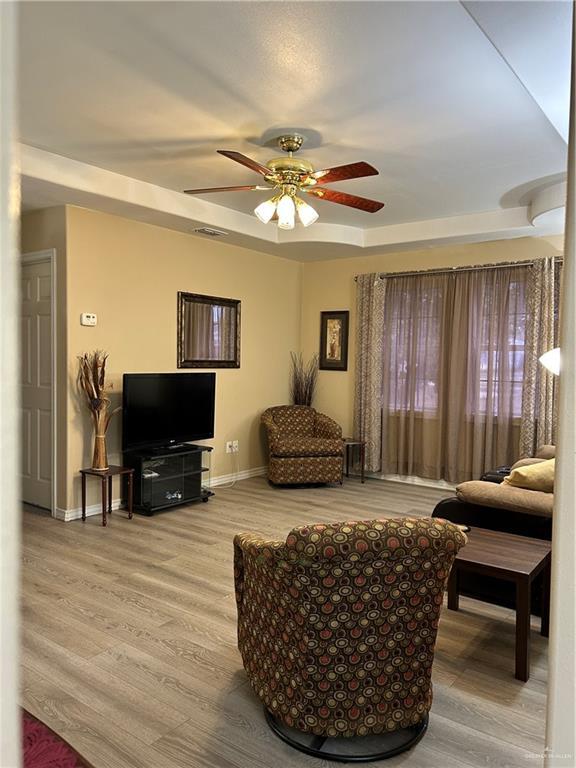 living room with hardwood / wood-style floors and ceiling fan