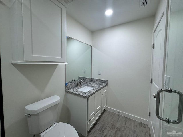 bathroom with hardwood / wood-style flooring, vanity, and toilet