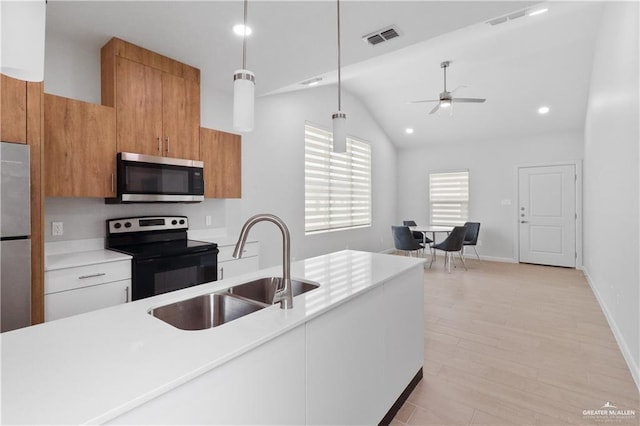 kitchen with sink, white cabinetry, light wood-type flooring, pendant lighting, and stainless steel appliances