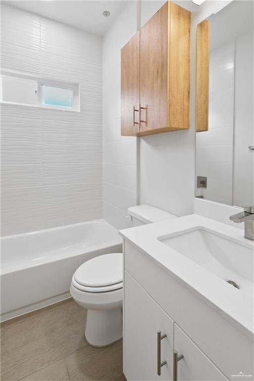 full bathroom with vanity, tiled shower / bath combo, and toilet