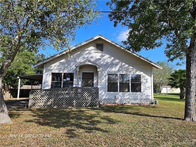 view of front of home with a front yard and a carport