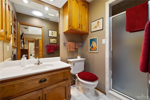 bathroom featuring toilet, vanity, tile patterned floors, and a shower with door