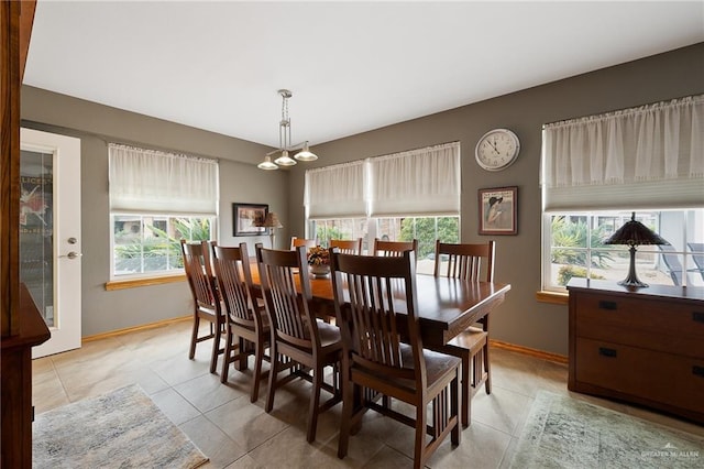 dining room with a notable chandelier, a healthy amount of sunlight, and light tile patterned flooring