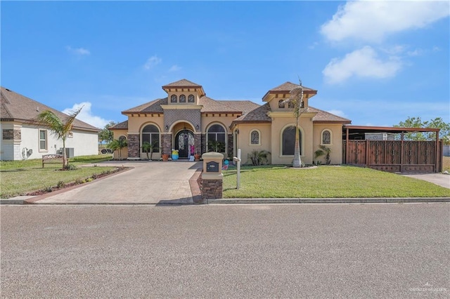 mediterranean / spanish house with concrete driveway, stucco siding, fence, and a front lawn