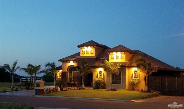 view of front of home with stucco siding and a front lawn