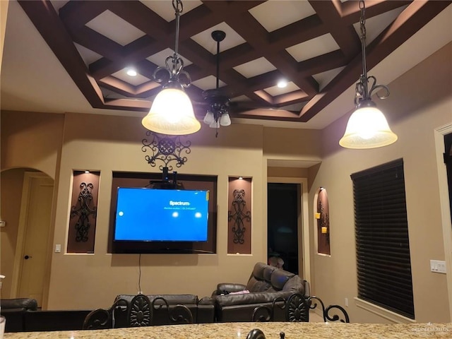 cinema room with arched walkways, beamed ceiling, coffered ceiling, and a high ceiling