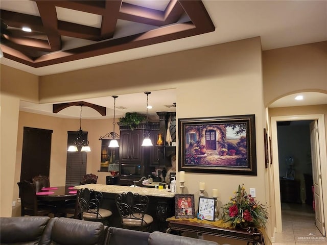 living area with beam ceiling, light tile patterned floors, arched walkways, and coffered ceiling
