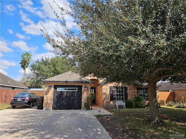 single story home with driveway, an attached garage, and fence