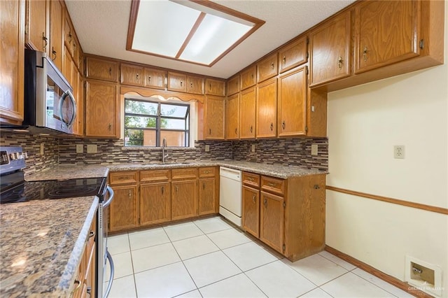 kitchen with sink, stainless steel appliances, tasteful backsplash, and light tile patterned floors