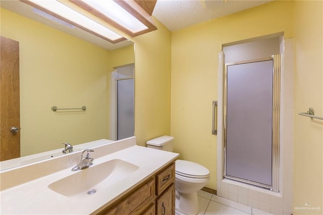 bathroom featuring toilet, a textured ceiling, walk in shower, tile patterned flooring, and vanity