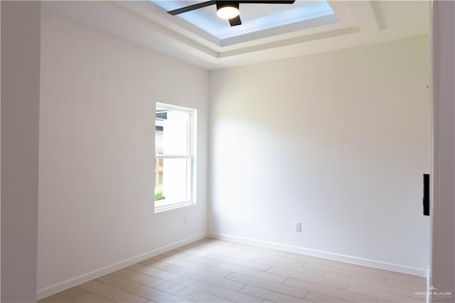 2221 N Woody St, Edinburg, TX 78541 - empty room with a ceiling fan, a tray ceiling, and light wood-style flooring