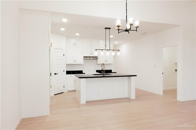 2221 N Woody St, Edinburg, TX 78541 - kitchen featuring dark countertops, recessed lighting, under cabinet range hood, white cabinetry, and a chandelier