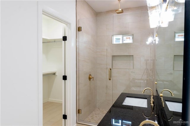 2221 N Woody St, Edinburg, TX 78541 - bathroom featuring a shower stall, a chandelier, a spacious closet, and double vanity