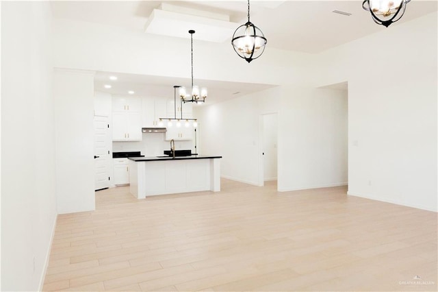 2221 N Woody St, Edinburg, TX 78541 - kitchen featuring dark countertops, a chandelier, white cabinets, open floor plan, and light wood-style floors