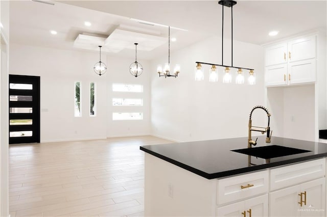 2221 N Woody St, Edinburg, TX 78541 - kitchen featuring dark countertops, light wood-type flooring, a tray ceiling, white cabinetry, and recessed lighting
