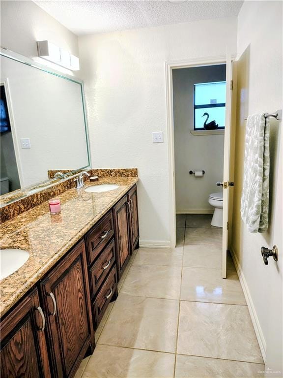 702 Clifford Dr, Weslaco, TX 78596 - bathroom with double vanity, a textured ceiling, and tile patterned floors