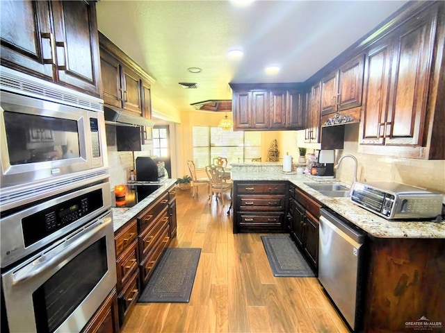 702 Clifford Dr, Weslaco, TX 78596 - kitchen featuring appliances with stainless steel finishes, wood finished floors, under cabinet range hood, recessed lighting, and decorative backsplash