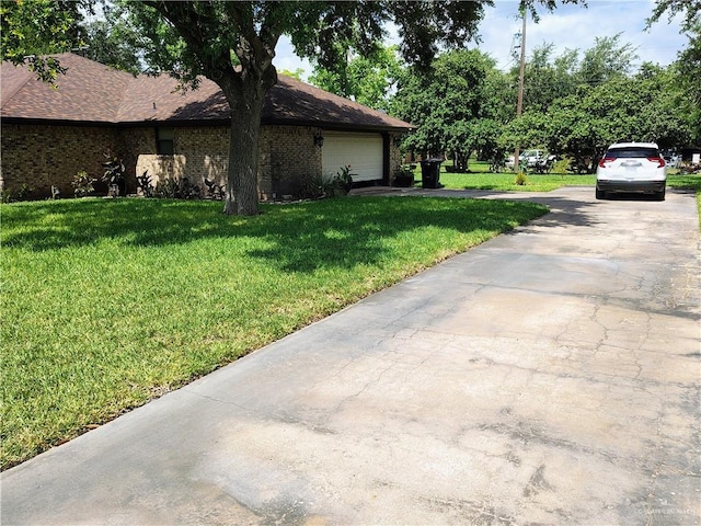 702 Clifford Dr, Weslaco, TX 78596 - view of home's exterior featuring a yard, driveway, and brick siding
