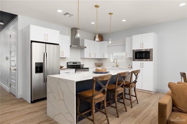 kitchen featuring a center island, white cabinets, hanging light fixtures, and appliances with stainless steel finishes