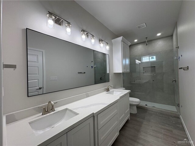 full bath with toilet, a sink, visible vents, and a shower stall
