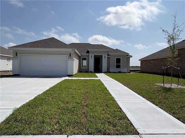view of front of property featuring stucco siding, an attached garage, driveway, a front lawn, and a shingled roof