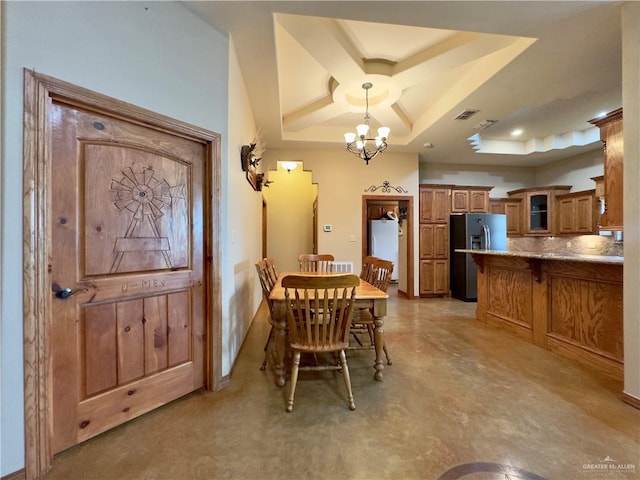 dining room featuring a raised ceiling and an inviting chandelier