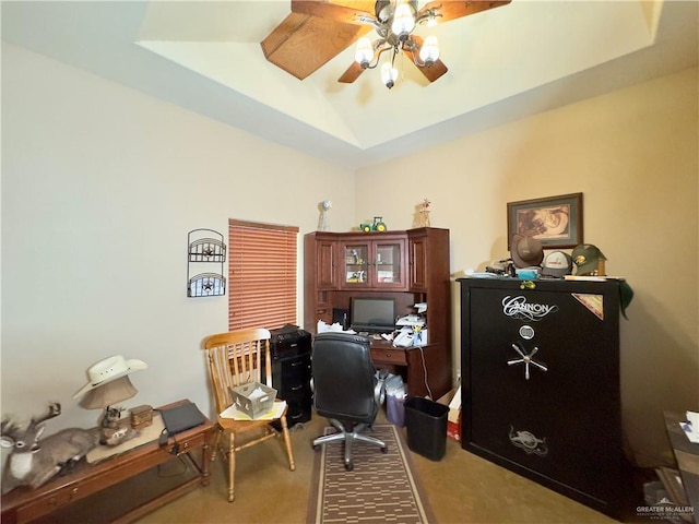 carpeted office space with ceiling fan and a tray ceiling