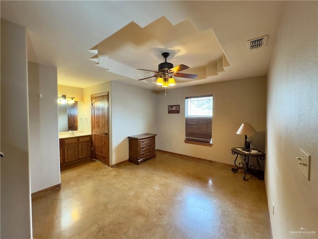 unfurnished bedroom featuring ceiling fan, a raised ceiling, and connected bathroom