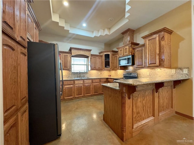 kitchen with sink, tasteful backsplash, kitchen peninsula, a breakfast bar, and appliances with stainless steel finishes