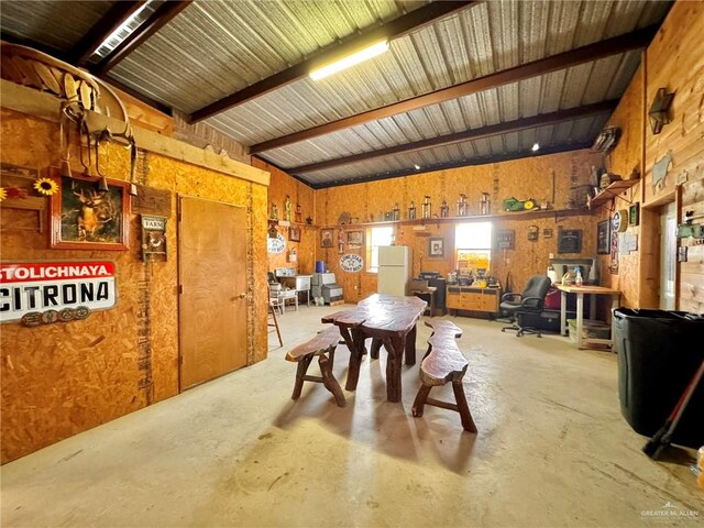 dining area with beamed ceiling and concrete flooring