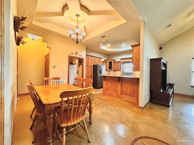 dining area featuring a chandelier and a raised ceiling