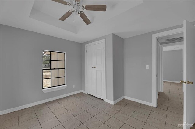 unfurnished bedroom featuring ceiling fan, light tile patterned flooring, and a closet