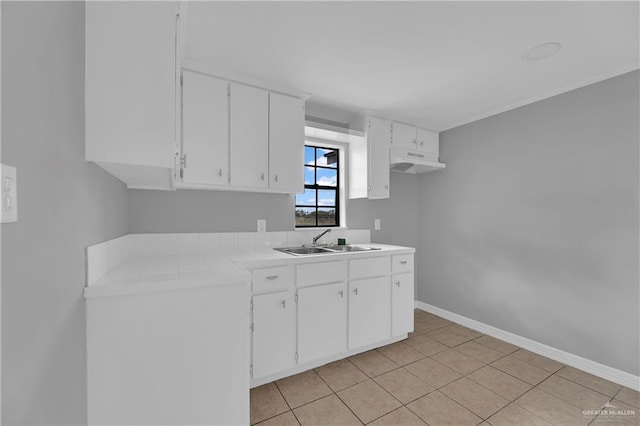 kitchen with white cabinets, light tile patterned floors, and sink