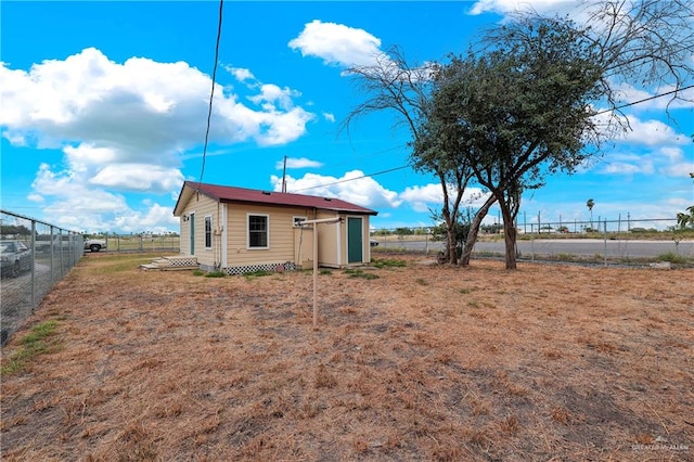 rear view of house featuring a storage shed