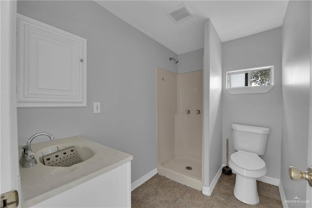 bathroom featuring tile patterned floors, toilet, walk in shower, and sink