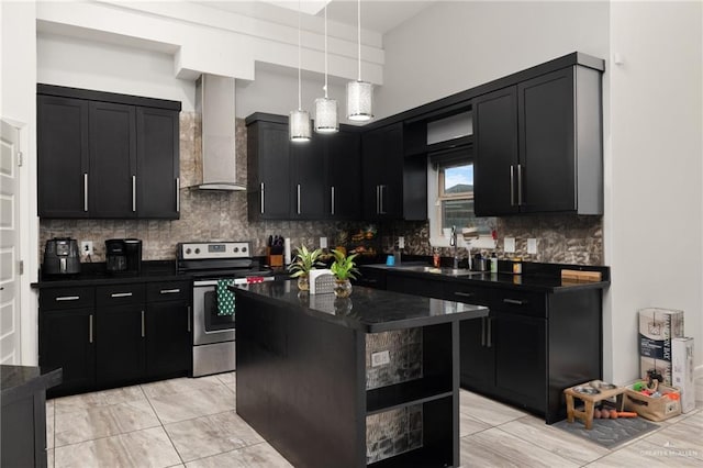 kitchen featuring a center island, wall chimney exhaust hood, hanging light fixtures, decorative backsplash, and stainless steel range with electric cooktop