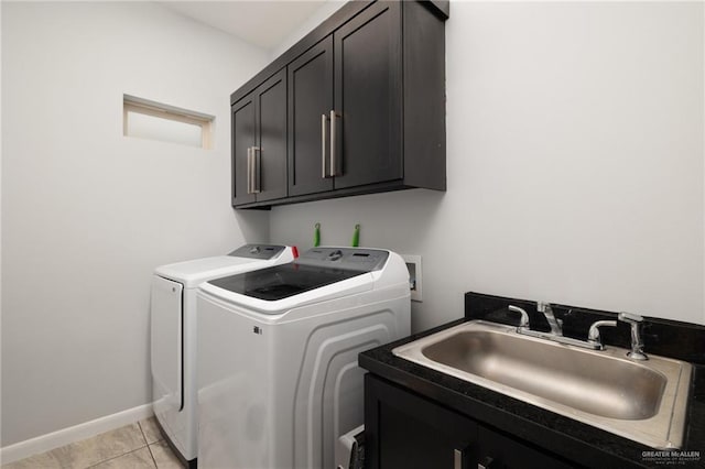 washroom with cabinets, light tile patterned floors, sink, and washing machine and clothes dryer