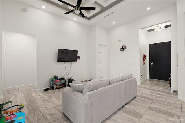 living room with ceiling fan and a towering ceiling