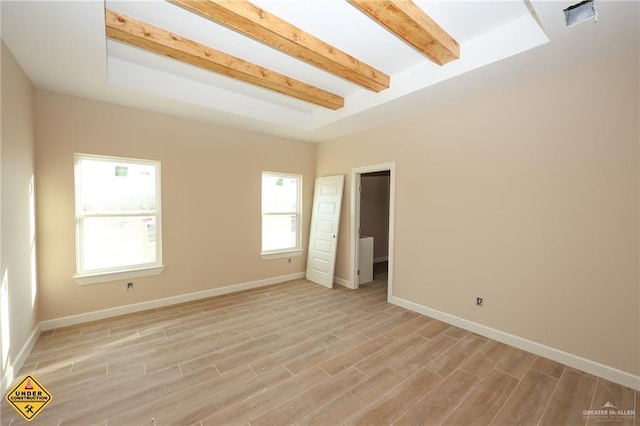 unfurnished room with beamed ceiling and light hardwood / wood-style floors