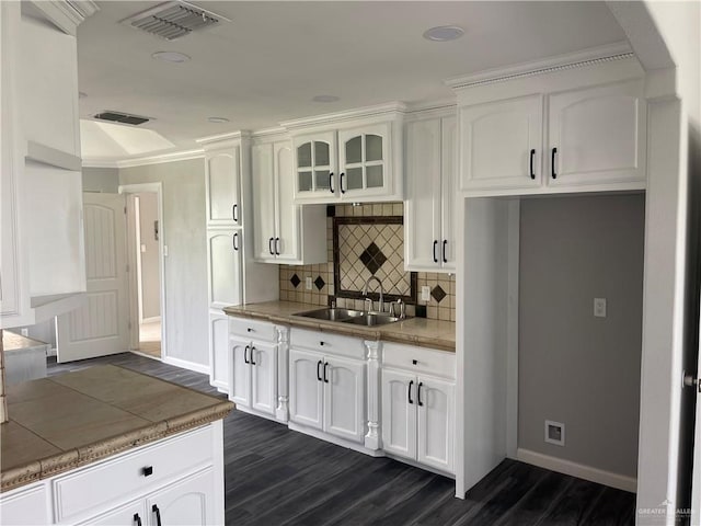 kitchen featuring sink, dark wood-type flooring, backsplash, tile countertops, and white cabinets