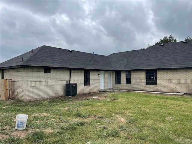 back of house with a yard and central AC