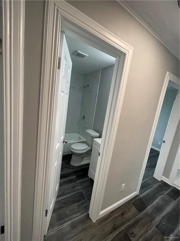 full bathroom with hardwood / wood-style flooring, vanity, toilet, and washtub / shower combination