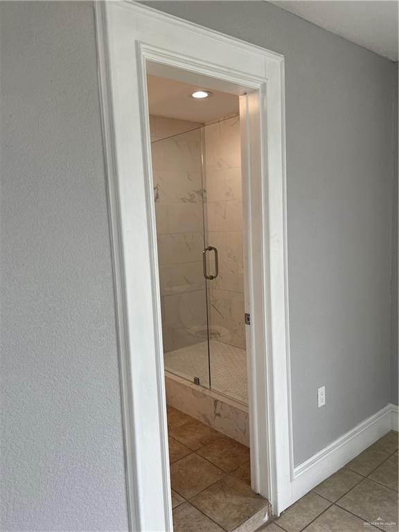 bathroom with tile patterned flooring and walk in shower