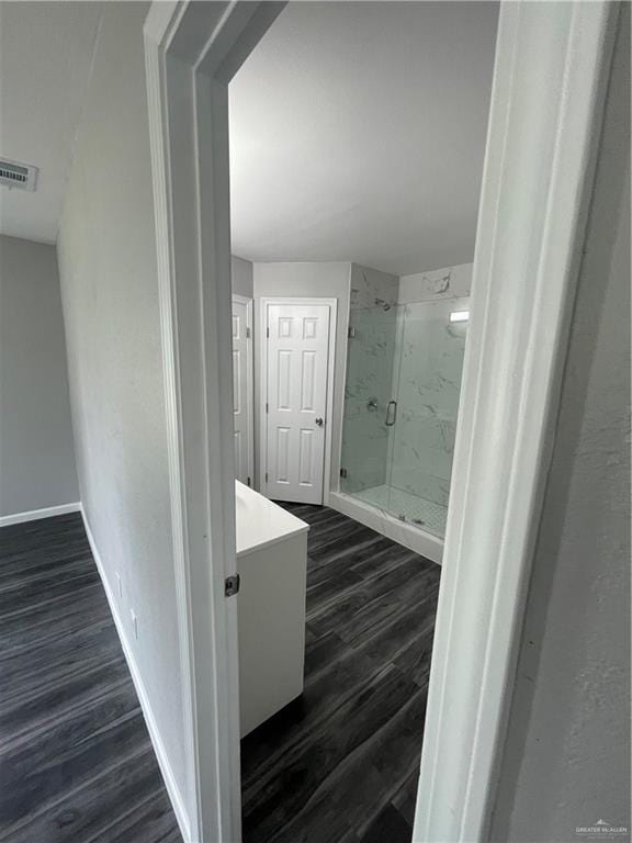 bathroom with a shower with door, vanity, and hardwood / wood-style flooring