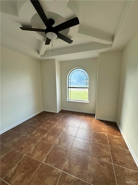 tiled empty room featuring ceiling fan