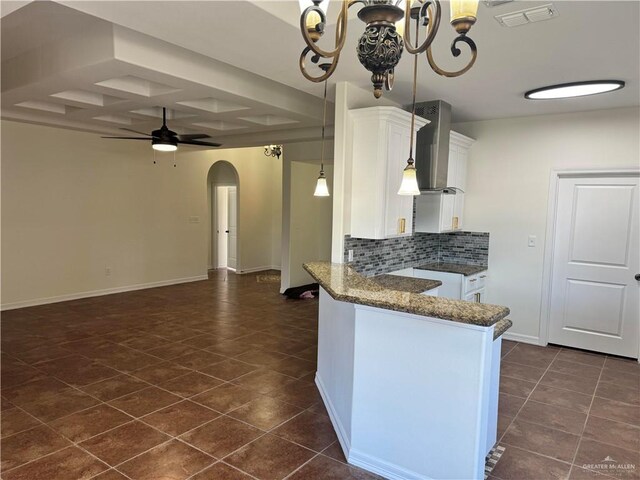 kitchen with white cabinets, ceiling fan with notable chandelier, tasteful backsplash, and kitchen peninsula